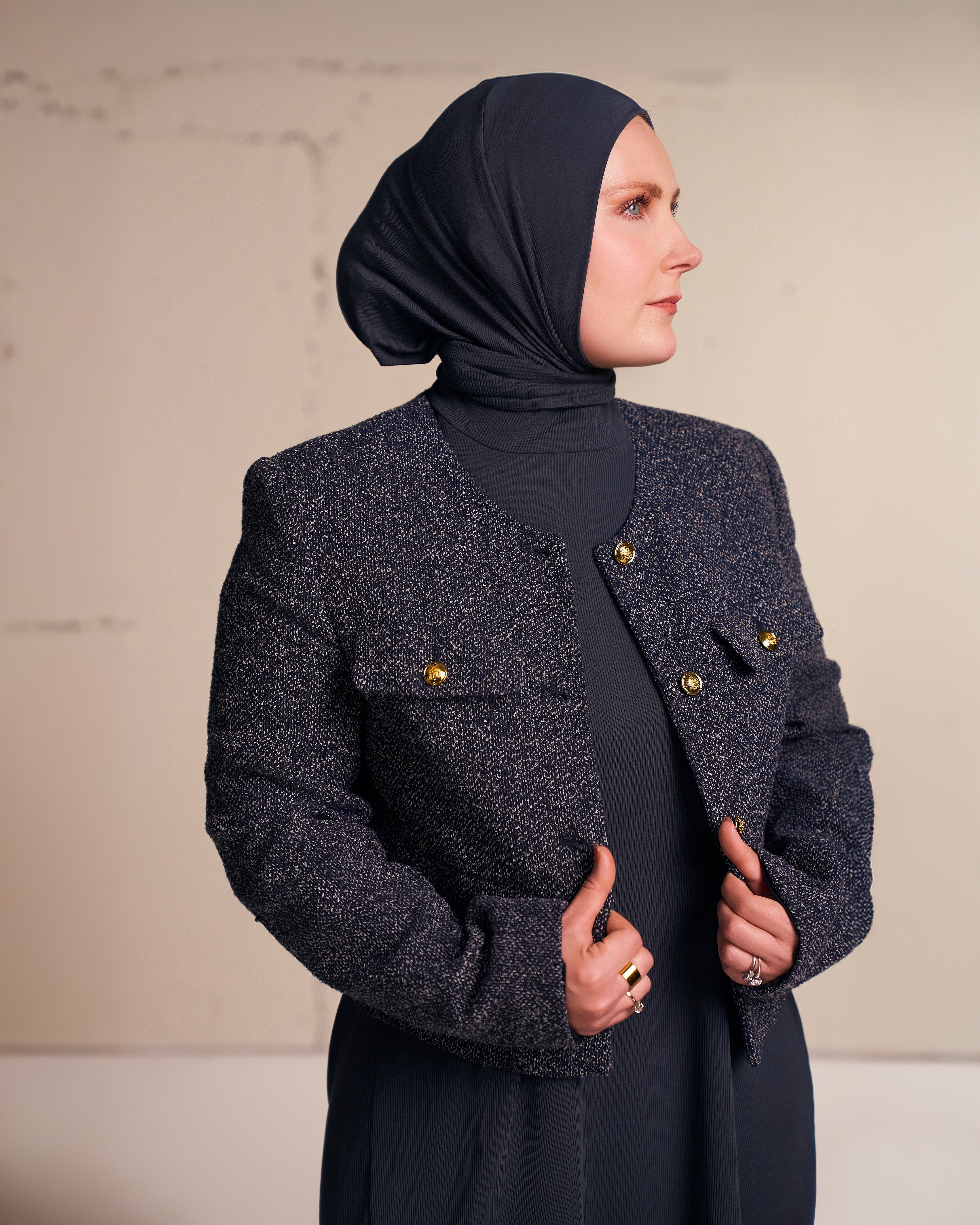 Woman wearing a charcoal Solo Snap Hijab styled with a textured blazer over a long tunic.
