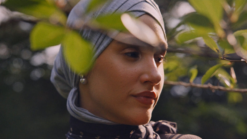Woman wearing a hijab with leaves in the foreground
