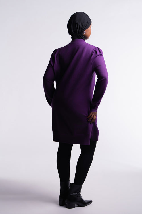 Berry Purple | Revive Fleece Pullover back view, mid-thigh length with puff shoulders, worn with black leggings and ankle boots