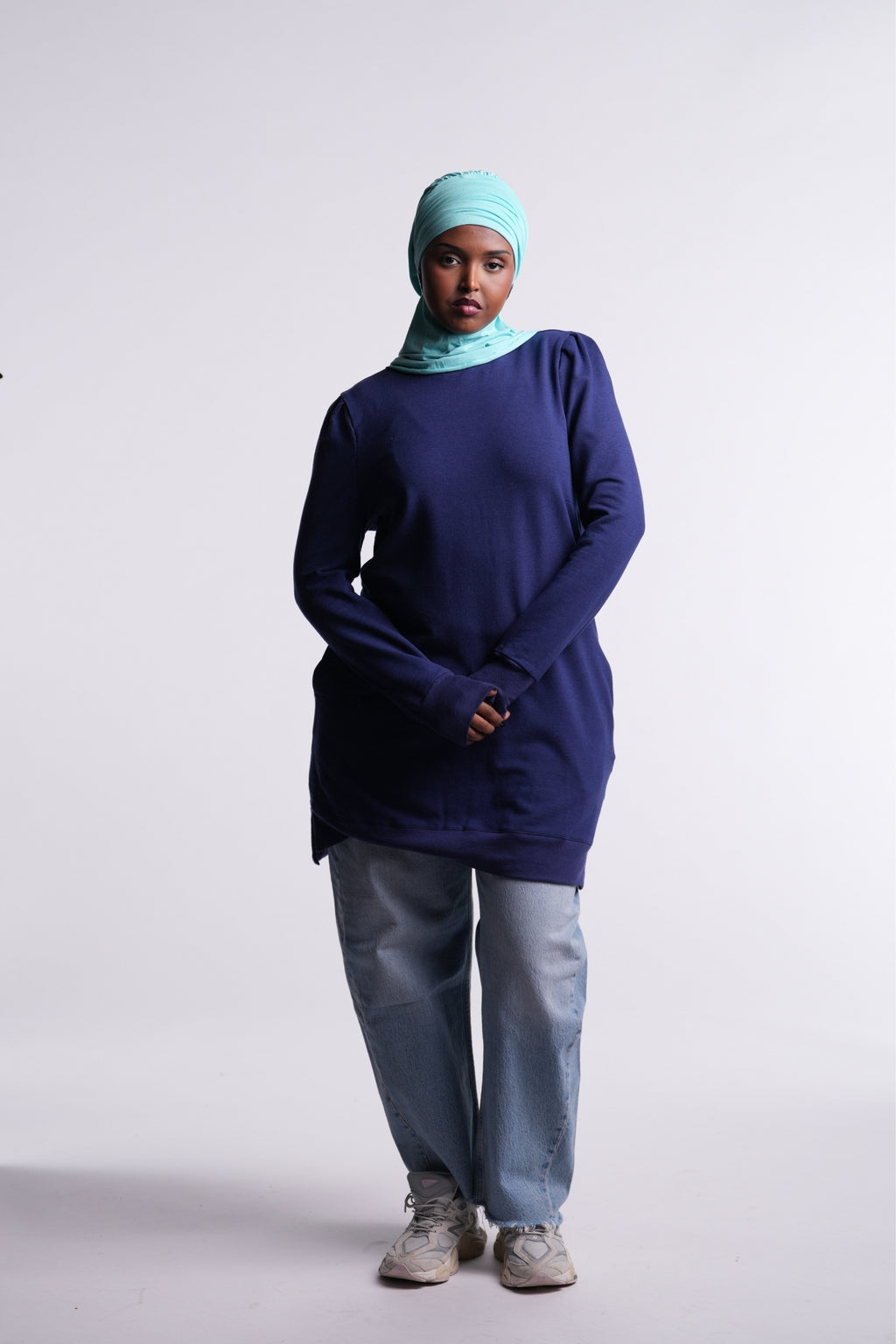 Revive Fleece Pullover front view, puff shoulders and split hem, worn with a turquoise hijab, light-wash jeans and sneakers