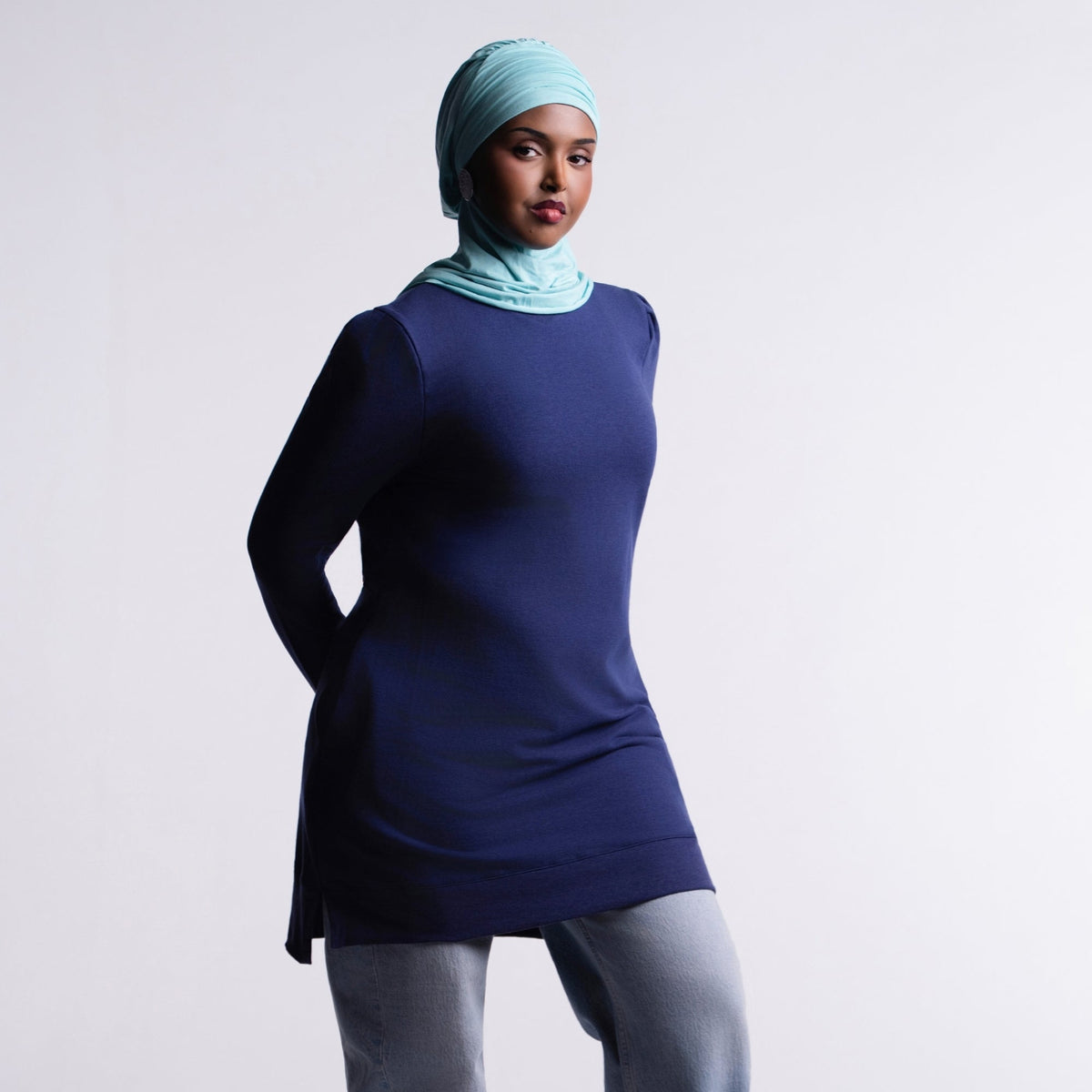 Revive Fleece Pullover front view, puff shoulders and split hem, worn with a turquoise hijab, light-wash jeans and sneakers
